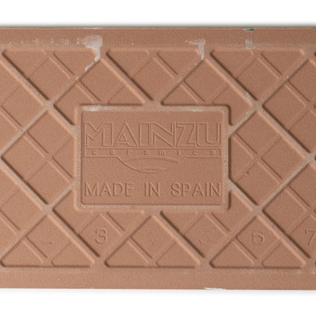 Un azulejo cerámico marrón texturizada muestra un patrón de cuadrícula con el texto en relieve: `MAINZU CERAMIC MADE IN SPAIN` y Un azulejo cerámico marrón texturizada muestra un patrón de cuadrícula con el texto en relieve: `MAINZU CERAMIC MADE IN SPAIN` y