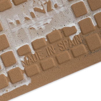 Le carreau présente une grille de motifs carrés en relief. partiellement recouvert d'adhésif, affichant le texte « MADE IN SPAIN