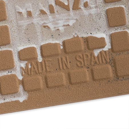 Braune Keramikfliesen weisen erhabene Gitterquadrate mit weißen Kleberesten auf. In der Mitte ist der Text „MADE IN SPAIN“ einge