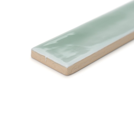 Un carreau rectangulaire, émaillé d'une surface brillante vert clair, repose sur un fond blanc uni, affichant son profil fin. Un carreau rectangulaire, émaillé d'une surface brillante vert clair, repose sur un fond blanc uni, affichant son profil fin.