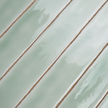 Rechteckige, glänzende, hellgrüne Fliesen. diagonal ausgerichtet. Fugenlinien trennen sie und erzeugen ein geordnetes Muster.