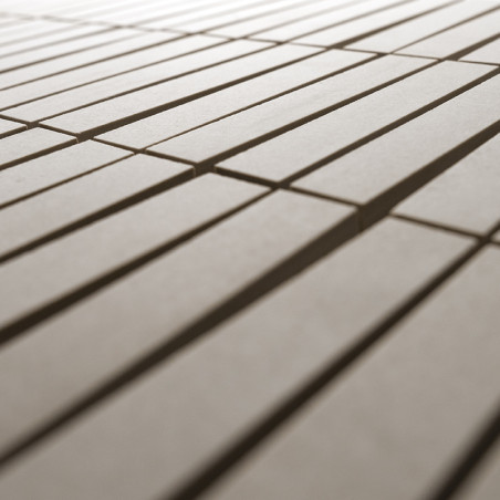 Los azulejos rectangulares de color beige se colocan en filas paralelas, creando un patrón lineal, rodeado por un fondo suavemen