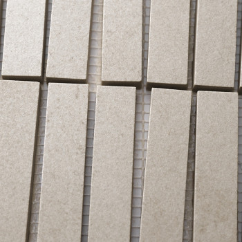Rechthoekige beige tegels zijn gerangschikt in verticale rijen, nauw uitgelijnd op een gaasrug, waardoor een gestructureerd, uni