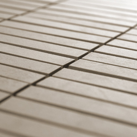 Rechteckige beige Fliesen liegen in parallelen Reihen und bilden ein einheitliches Muster in einer geräumigen, gleichmäßig beleu