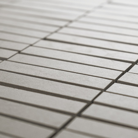 Ladrilhos retangulares, alinhados em um padrão de grade, formam uma superfície lisa e contínua. A cor cinza claro cria uma aparê