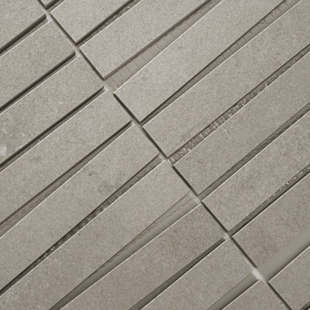 Los mosaicos rectangulares de color gris claro están alineados en filas paralelas, creando un patrón de cuadrícula. Están espaci