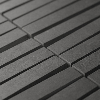 Les carreaux rectangulaires gris foncé s'alignent en rangées parallèles, créant un motif rythmé. Les carreaux forment une surfac