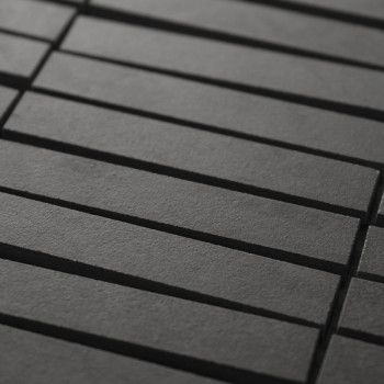 Les carreaux noirs rectangulaires sont disposés en quinconce, créant une texture géométrique subtile. Les carreaux présentent de