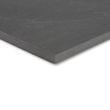 Um ladrilho cerâmico cinza escuro com uma superfície lisa fica inclinado, mostrando sua espessura e cantos afiados contra um fun