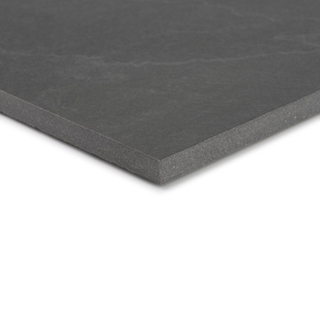 Un carreau de céramique gris foncé avec une surface lisse est posé en angle, mettant en valeur son épaisseur et ses angles vifs 