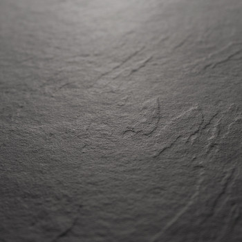 Un carreau de pierre sombre et texturé présente des rainures naturelles et de subtiles variations de tons, évoquant une surface 