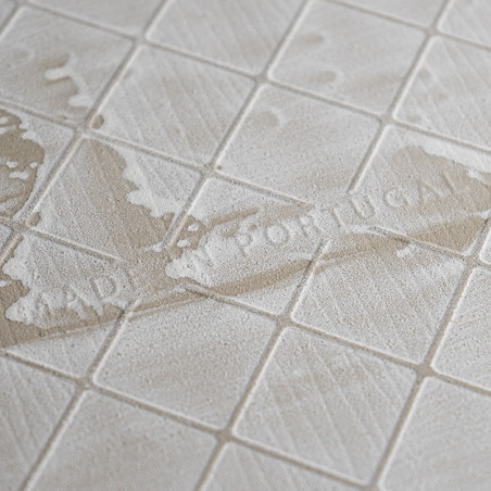 Les carreaux carrés beiges ont une surface texturée avec de subtils motifs diagonaux. Le texte pâle indique « MADE IN PORTUGAL »