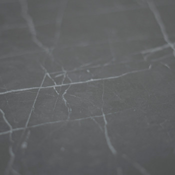 Un carreau de marbre gris foncé avec de fines veines blanches s'étend en diagonale sur la surface lisse, sur un fond uniforme.