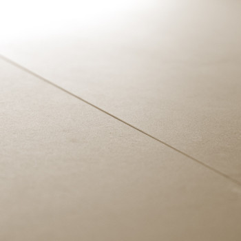 Un carreau lisse et beige repose sur une surface plane, présentant une ligne de coulis subtile et droite divisant sa surface sou