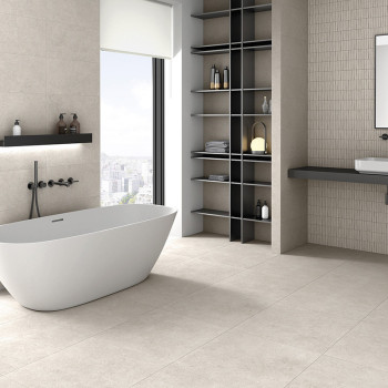 Une baignoire blanche se dresse dans une salle de bains moderne et minimaliste avec des carreaux beiges, une grande fenêtre et d