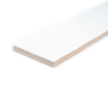 Um ladrilho cerâmico branco retangular repousa sobre um fundo branco, exibindo uma superfície lisa e uma borda levemente bege.
