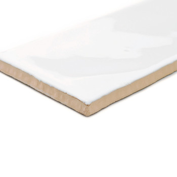 Rectangular ceramic tile with glossy white glaze, lying flat, showing its thickness and unfinished brown underside, against a pl