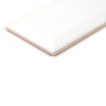 Un azulejo cerámico rectangular de color blanco brillante descansa sobre una superficie blanca lisa, enfatizando sus bordes bise