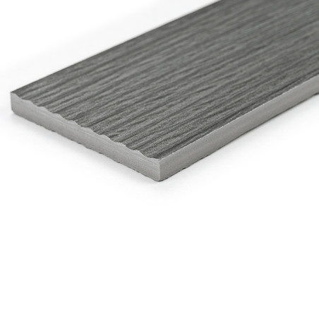 Un azulejo gris rectangular con una textura similar a la madera descansa sobre un fondo blanco liso, mostrando sus bordes suaves