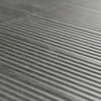 Les carreaux gris texturés présentent des crêtes parallèles surélevées, créant un motif rayé sur une surface lisse et uniforme.