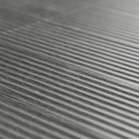 Les carreaux gris texturés présentent des crêtes parallèles surélevées, créant un motif rayé sur une surface lisse et uniforme.