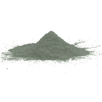 Une poudre gris verdâtre forme un petit monticule dispersé sur une surface blanche, suggérant une préparation au mélange ou à l'