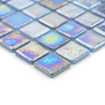 Ladrilhos de vidro iridescentes refletem padrões de luz coloridos, dispostos em uma grade geométrica sobre uma superfície branca