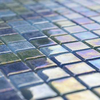 Shimmering glass tiles reflect light, creating a colorful pattern across a smooth, geometric mosaic surface.