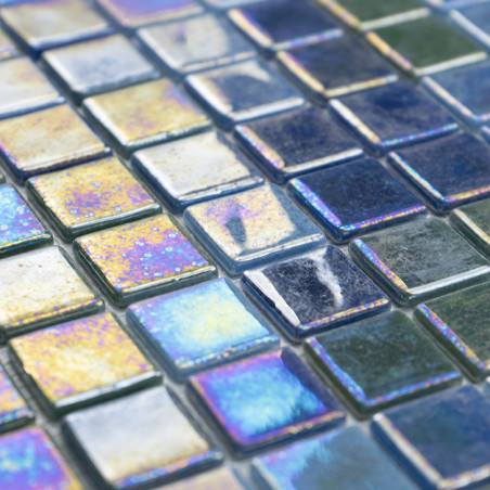 Square glass tiles shimmer with iridescent colors, reflecting light in a grid pattern on a flat surface.