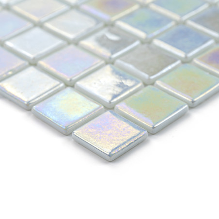 Ladrilhos de vidro iridescentes brilham, dispostos em um padrão de grade, criando um mosaico colorido e reflexivo em uma superfí