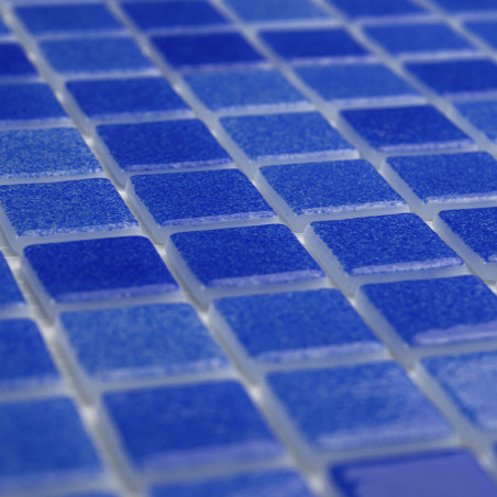 Blauwe glastegels vormen een vlak liggend raster en creëren een glinsterend oppervlak met lichtreflecties. Blauwe glastegels vormen een vlak liggend raster en creëren een glinsterend oppervlak met lichtreflecties.