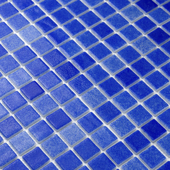 Blauwe glastegels vormen een mozaïekpatroon, waardoor een gestructureerd oppervlak ontstaat, mogelijk voor een muur of vloer.