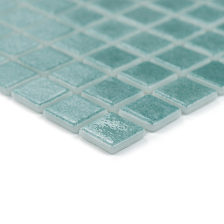 Azulejos cuadradas de vidrio verde azulado dispuestas en forma de cuadrícula, que muestran una superficie brillante y reflectant