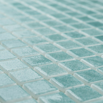 Los azulejos de vidrio forman un mosaico, creando un patrón brillante sobre una superficie plana, con la luz realzando su tono t