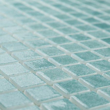 Les carreaux de verre forment une mosaïque, créant un motif chatoyant sur une surface plane, la lumière rehaussant leur teinte t