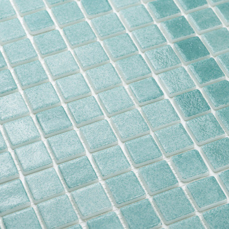 Los azulejos de vidrio turquesa están cuidadosamente dispuestos en un patrón de cuadrícula, creando una superficie texturizada y