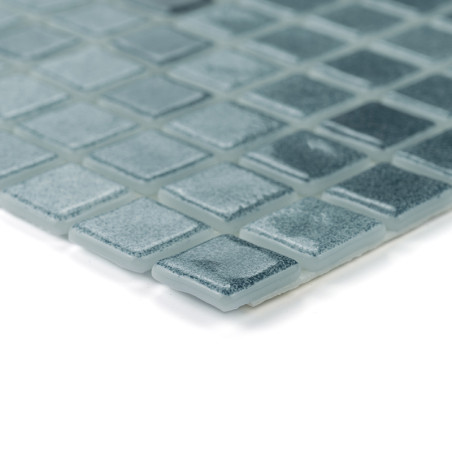 Ordentlich angeordnete quadratische Glasfliesen, die das Licht reflektieren, erzeugen eine strukturierte, schimmernde Oberfläche