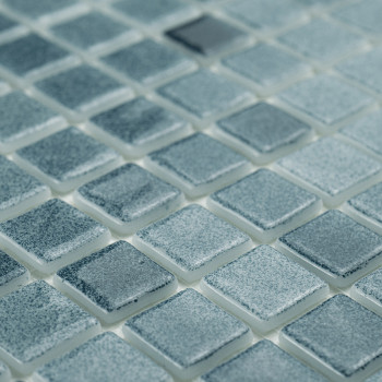 Quadratische Glasfliesen schimmern dezent und reflektieren das Licht über ein Gitter, wodurch ein strukturiertes, gleichmäßiges 