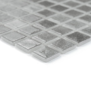 Les carreaux de verre carrés reposent sur un motif en grille, reflétant subtilement la lumière dans un cadre minimaliste et mode