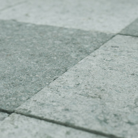 Los azulejos de piedra gris dispuestas en una cuadrícula se encuentran uniformemente en el suelo, formando una superficie textur