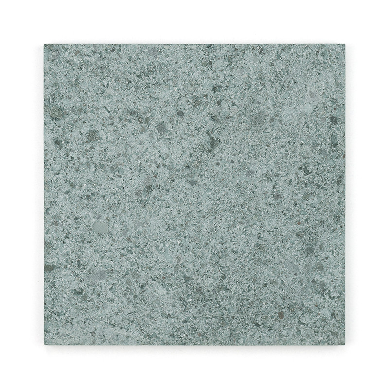 Baldosa de piedra cuadrada con textura gris moteada, apoyada sobre un fondo blanco liso.