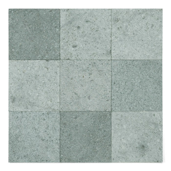 Um ladrilho de pedra verde com uma superfície texturizada, deitado sobre um fundo branco.