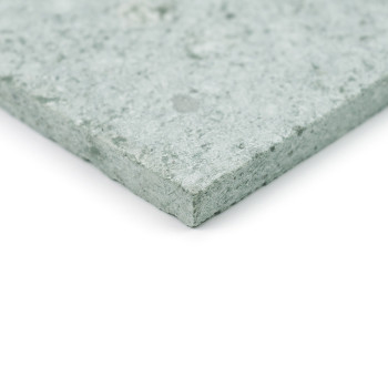Een groene steentegel met een gestructureerd oppervlak, plat liggend tegen een witte achtergrond.