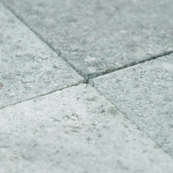 Les carreaux de pierre grise forment une surface lisse et texturée disposée selon un motif de grille soigné.