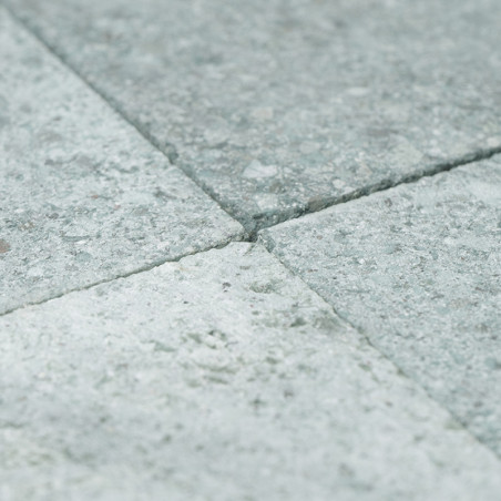 Los azulejos de piedra gris forman una superficie lisa y texturizada dispuesta en un elegante patrón de cuadrícula.