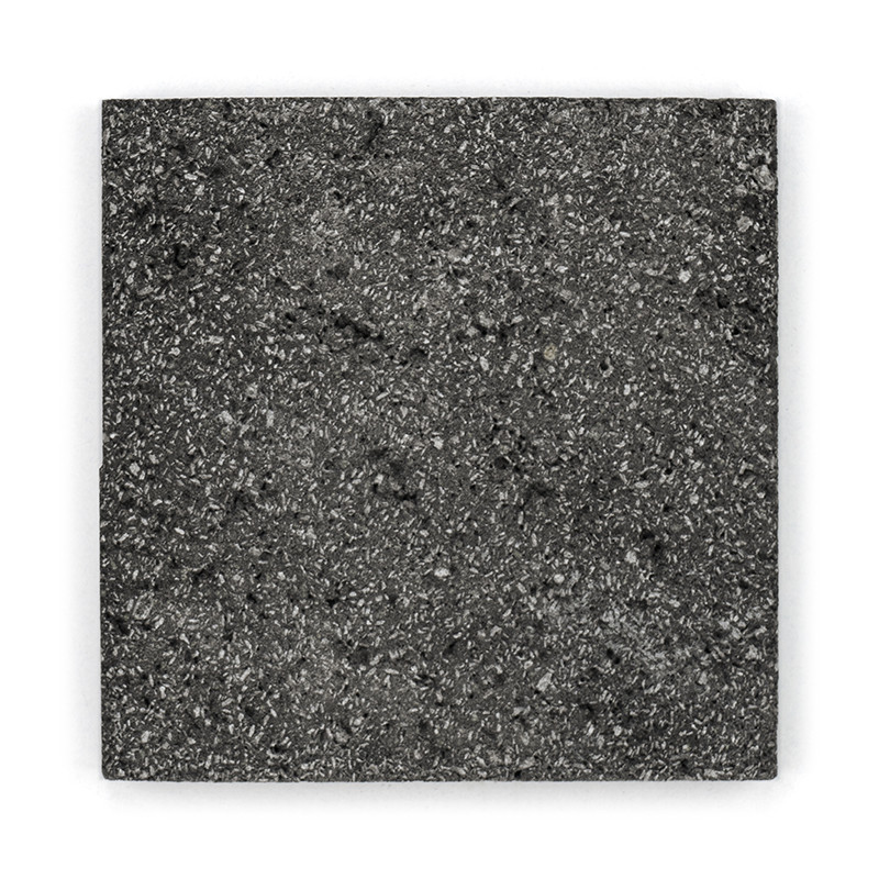 Vierkante steentegel met een gespikkeld, gestructureerd oppervlak. plat rusten tegen een witte achtergrond.