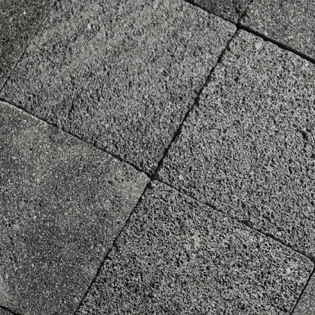 Les carreaux de pierre grise forment un motif en grille, affichant une texture rugueuse, parfaitement alignée dans un décor exté