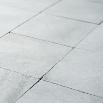 Graue Steinfliesen bilden ein geometrisches Muster, das sich sauber überschneidet und so eine glatte, einheitliche Oberfläche in