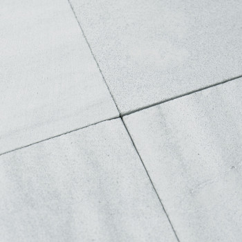 Four light gray stone tiles meet at the corners, forming a cross pattern. The surface appears smooth and slightly matte.