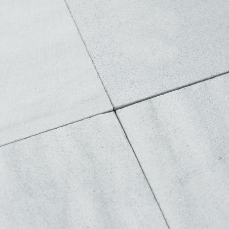 Four light gray stone tiles meet at the corners, forming a cross pattern. The surface appears smooth and slightly matte.